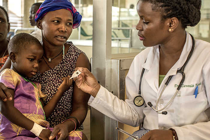Un'infermiera del Lacor Hospital misura la febbre a un bambino