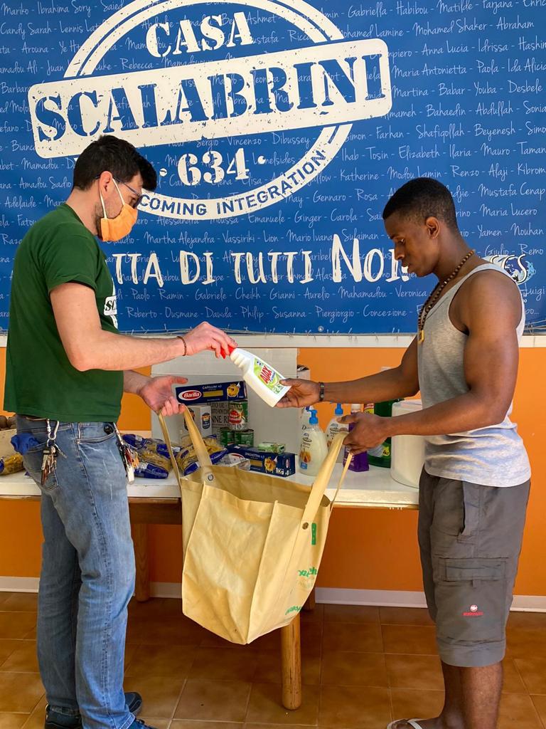 volontario dei missionari Scalabriniani che aiuta un migrante